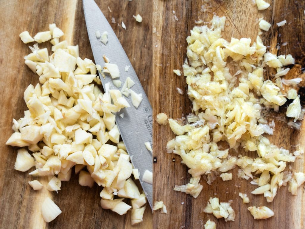 knife chopping up garlic that turns into garlic paste