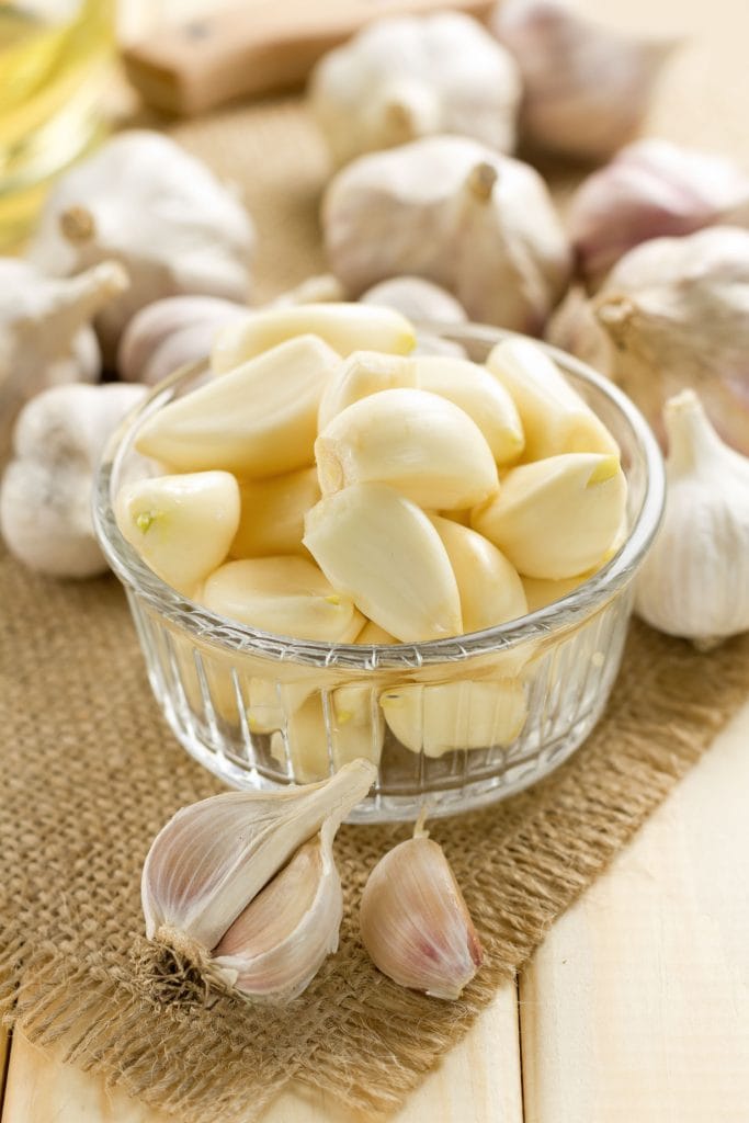 peeled garlic in glass bowl