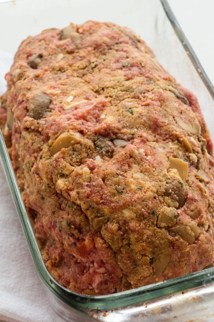 uncooked meatloaf in baking dish in loaf form ready to go into the oven