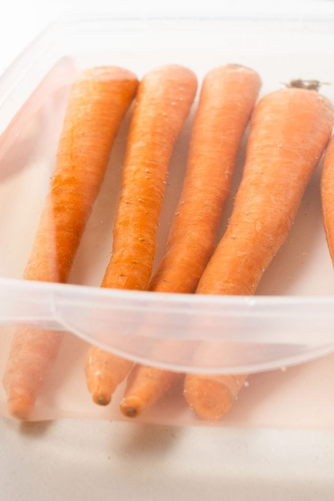 carrots covered in water in container