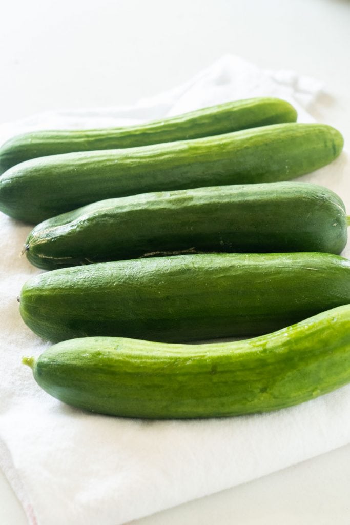 cucumbers laying on paper towel  on white background