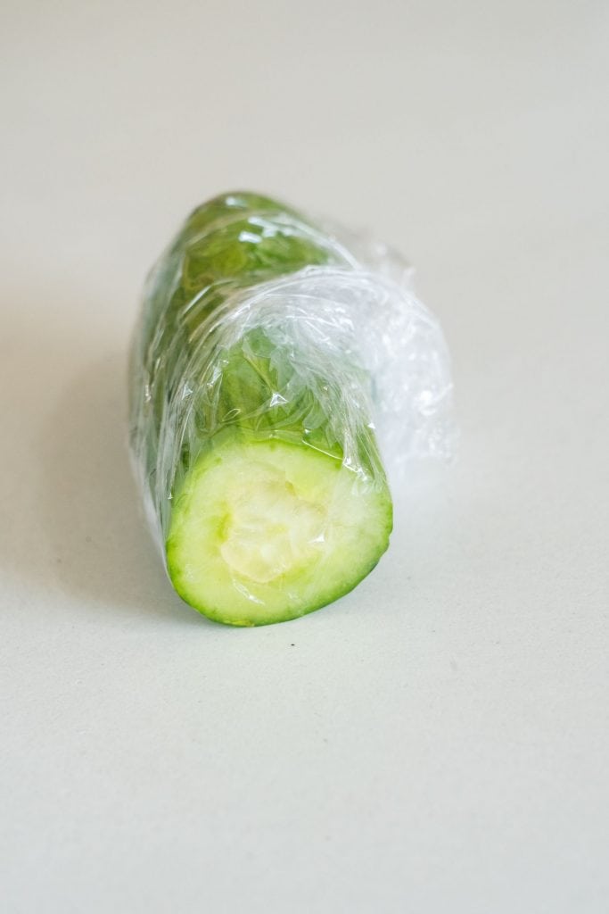 cut cucumber with plastic wrap around it