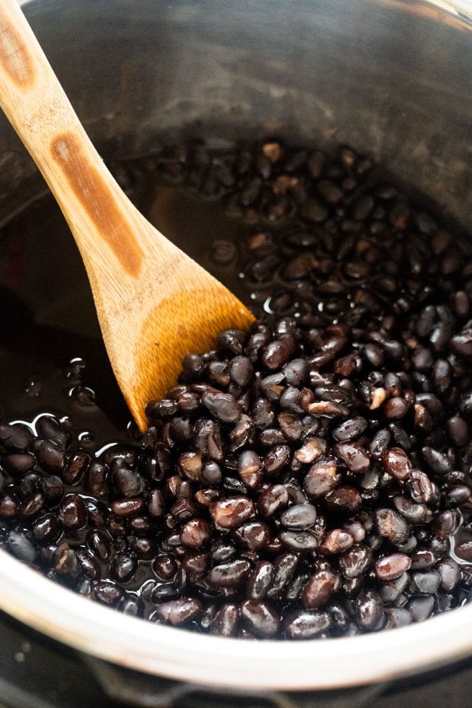 wooden spoon in instant pot with black beans
