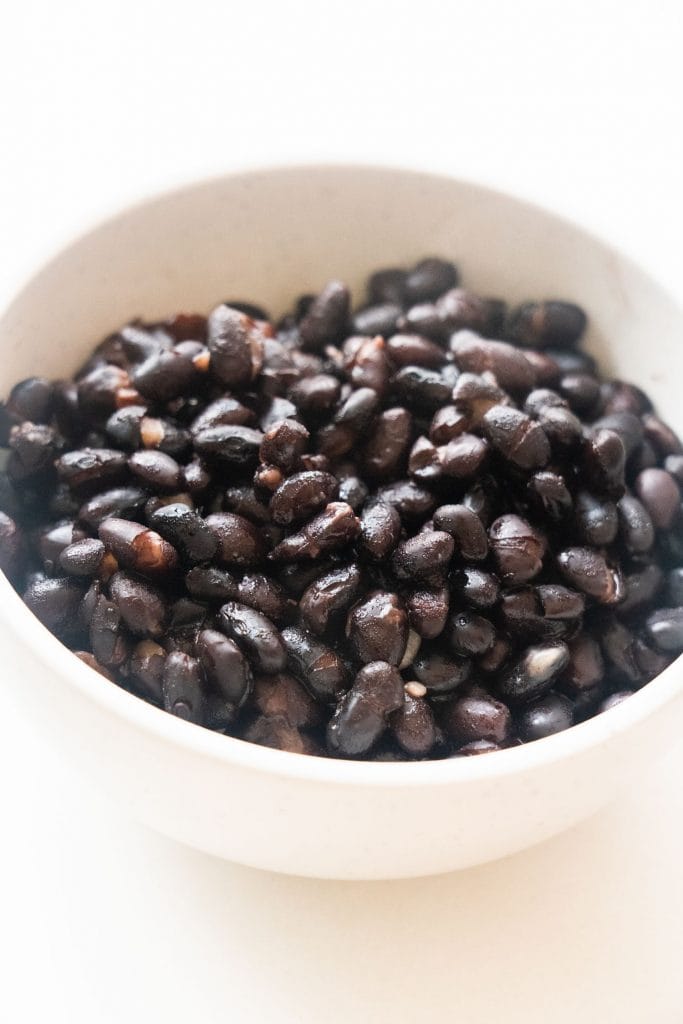 white bowl filled with cooked black beans