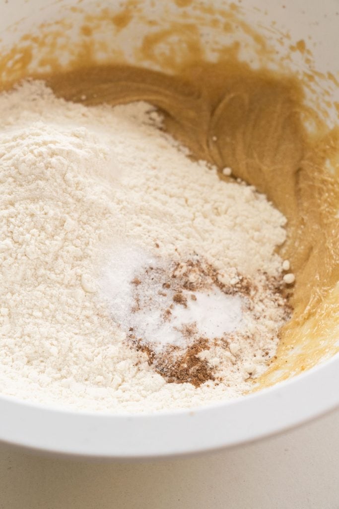 flour, salt, baking powder and nutmeg being added to bowl