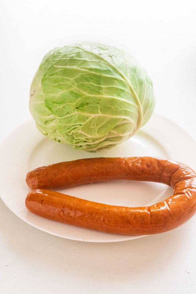 head of cabbage and sausage on white plate