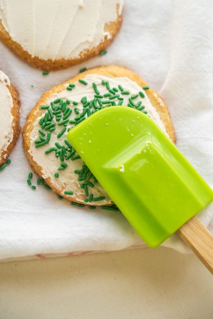 spatula pressing down sprinkles on cookie