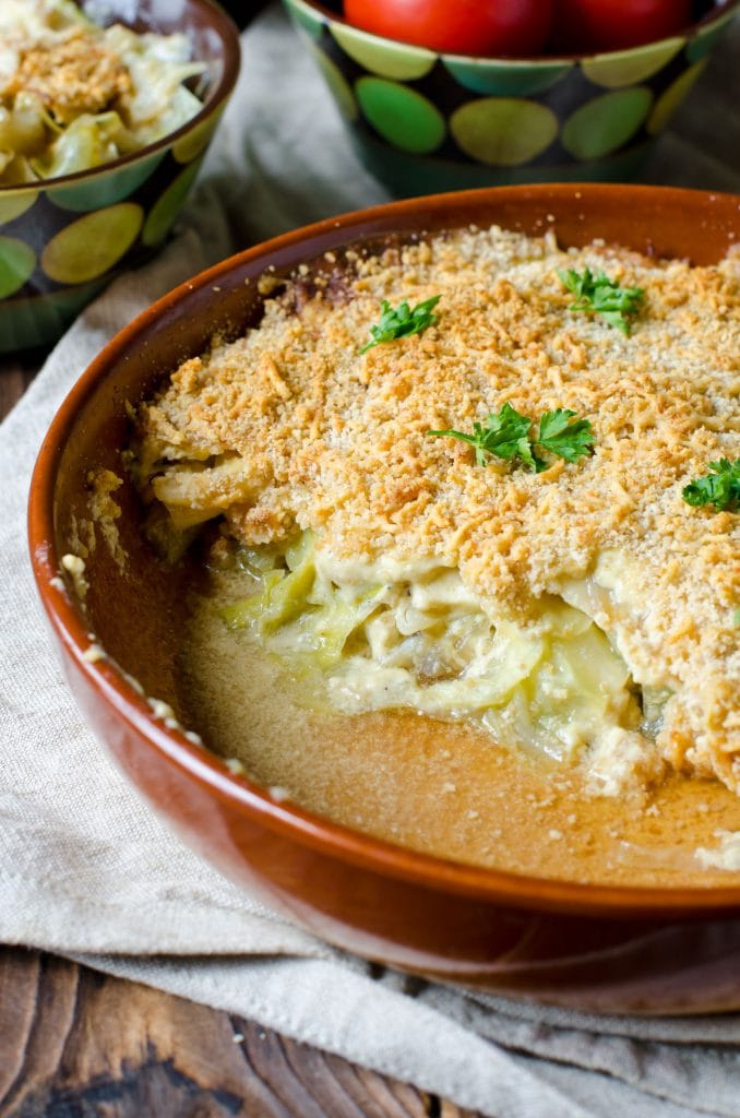 creamy cabbage casserole in baking dish with some of it removed and served