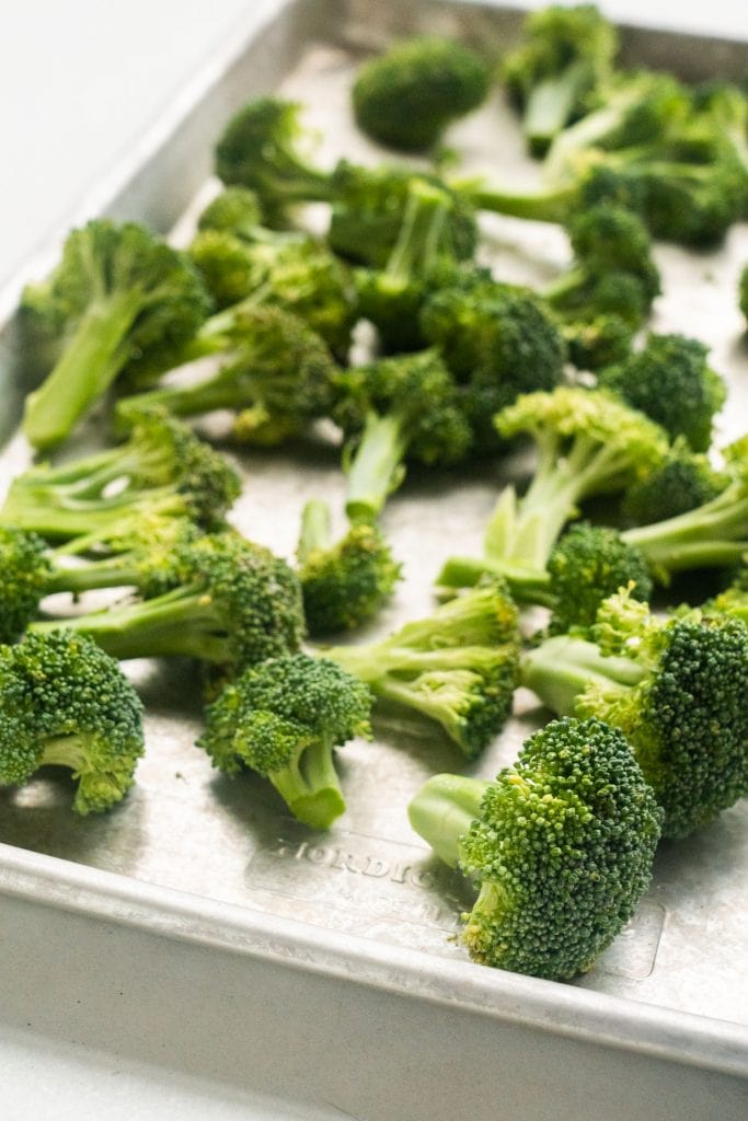 raw broccoli florets on baking sheet