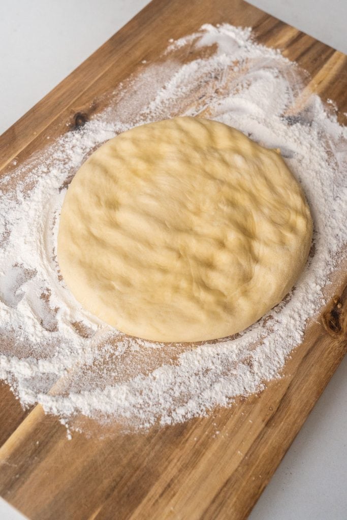 punched down dough on floured cutting board
