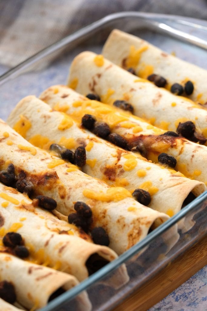 black bean tacos with melted cheese on top in casserole dish