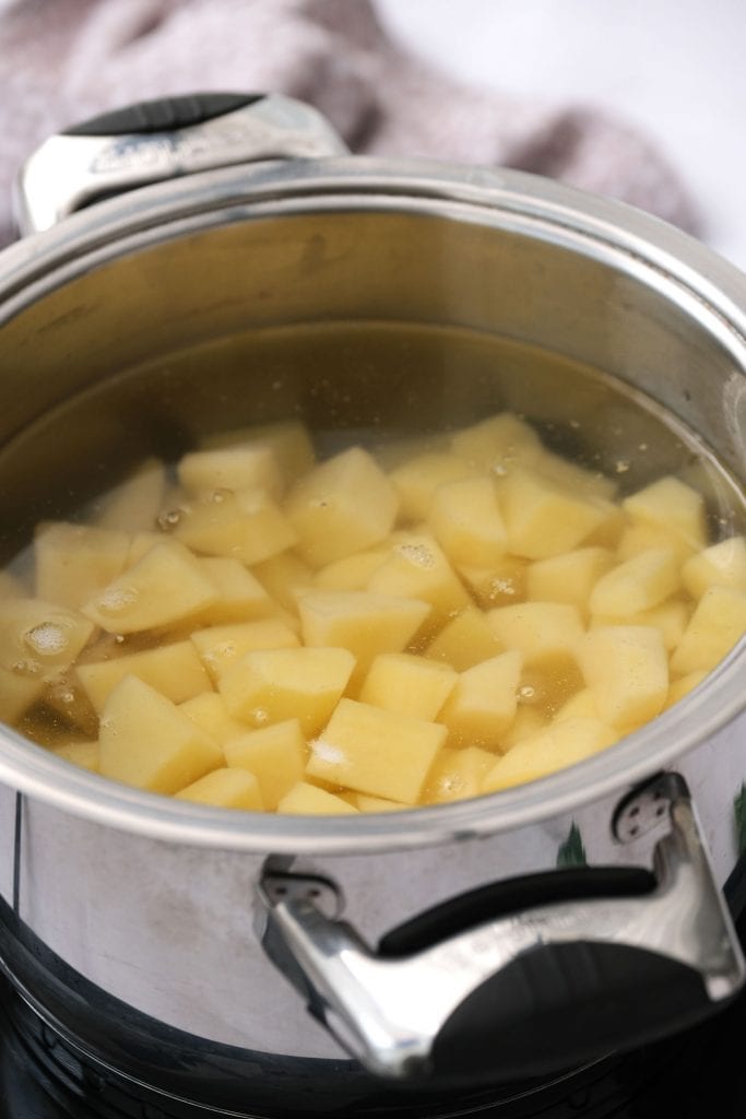 cubed potatoes in water being boiled to make mashed potatoes.