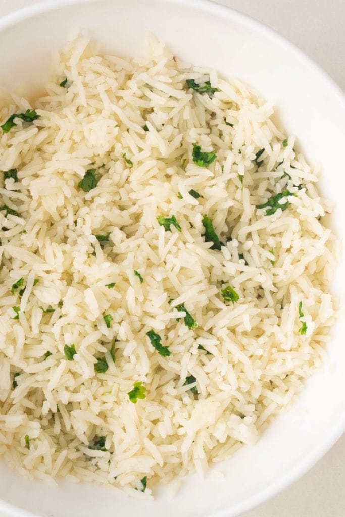 fluffy cilantro lime rice in white bowl, ready to be served.