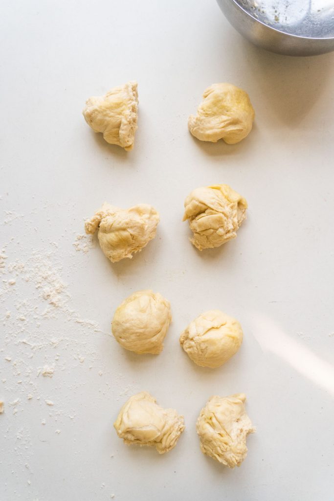 8 pieces of dough ripped up on table.