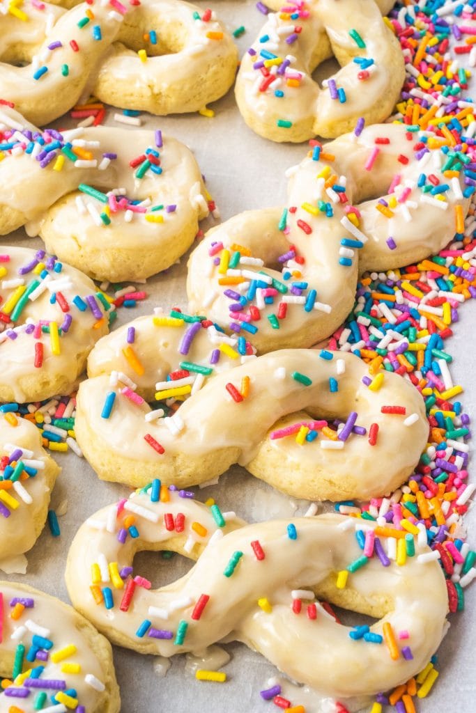 baked golden brown italian anise cookies with vanilla glaze and sprinkles