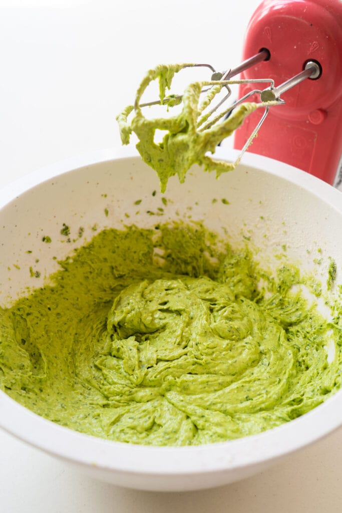 cake mix and spinach mixed up in bowl with hand mixer.