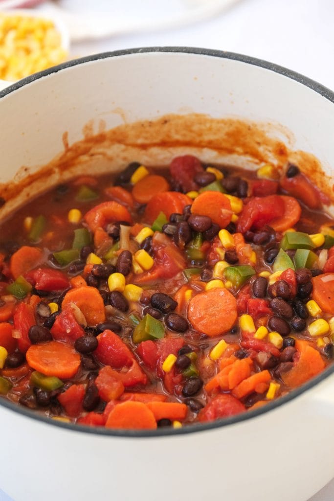 black bean chili mixed in white pot.
