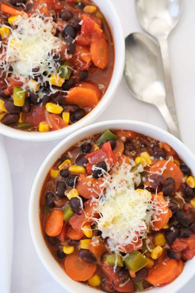 bowl of black bean chili filled with vegetables in white bowl