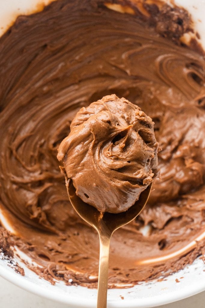 spoon of the best chocolate brownie frosting in bowl. 