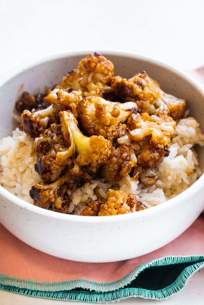 general tsos cauliflower served on rice in bowl for dinner.