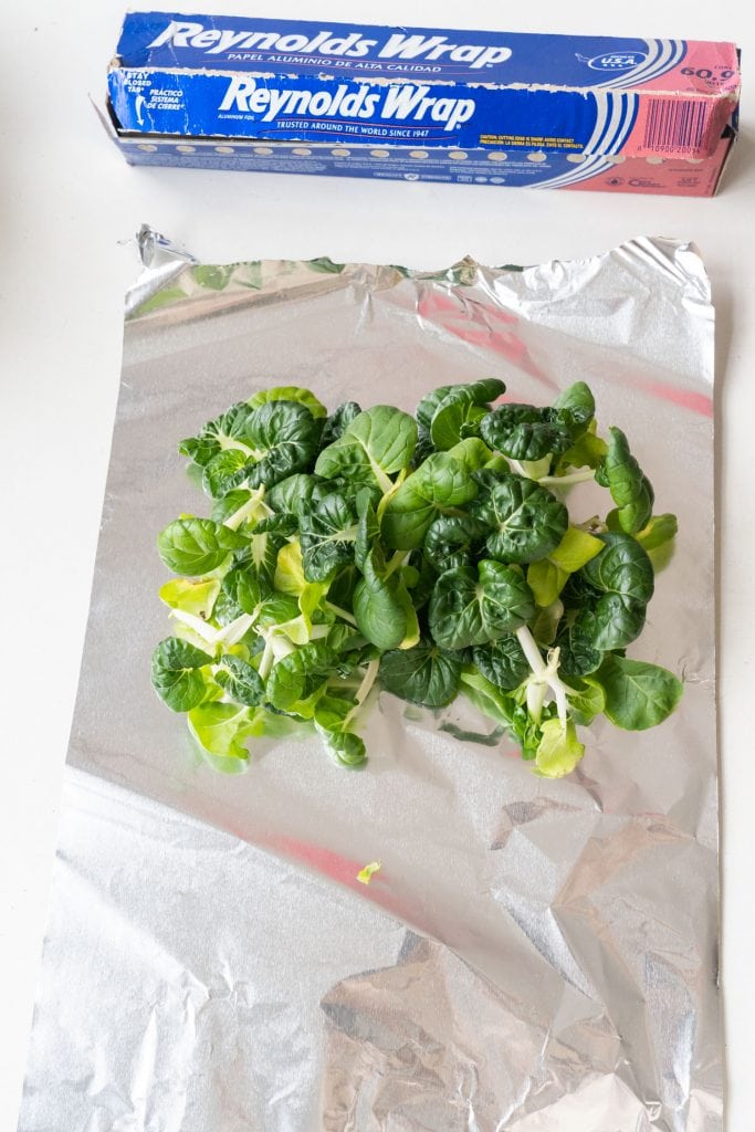 bok choy on top of piece of aluminum foil