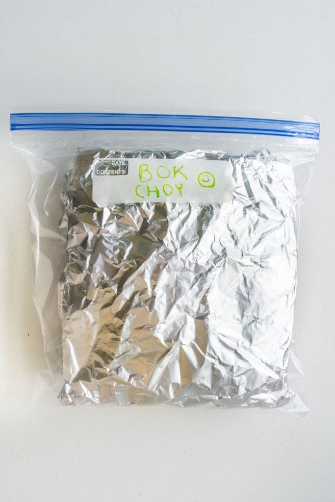 bok choy in aluminum foil inside plastic bag