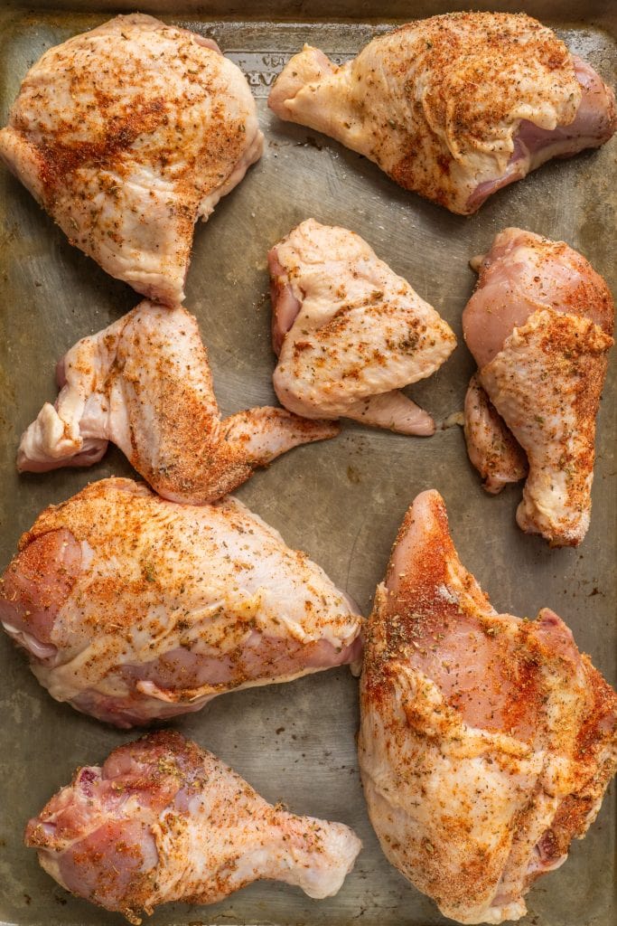 raw chicken on baking sheet.