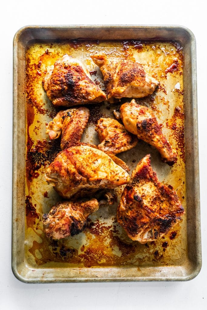 baked chicken on baking sheet on white table.