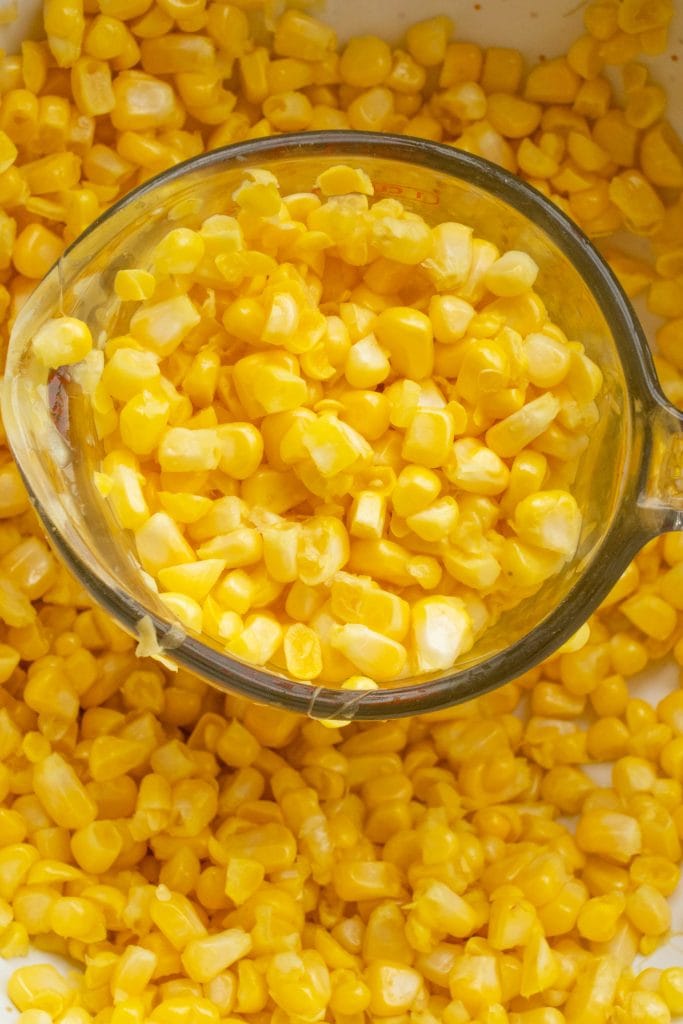 1 cup measuring cup filled with fresh corn.