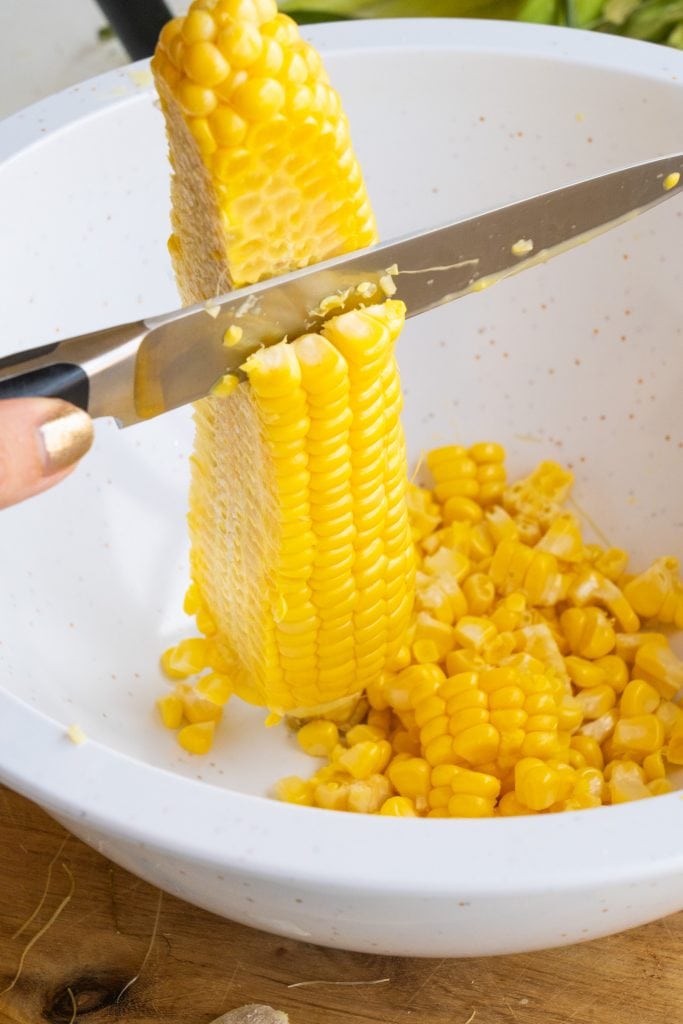 knife cutting kernels off cob.