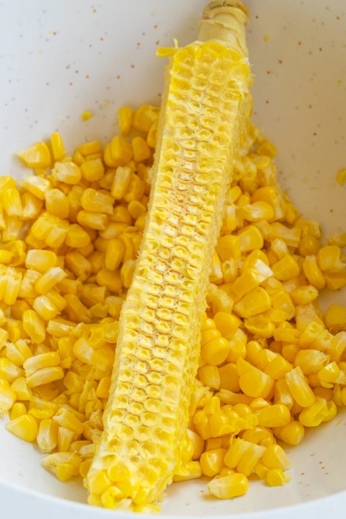 corn cob that has had it's kernels removed sitting in white bowl.