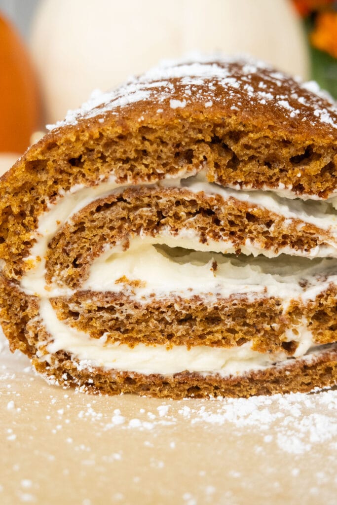 closeup of pumpkin roll with cream cheese filling inside.