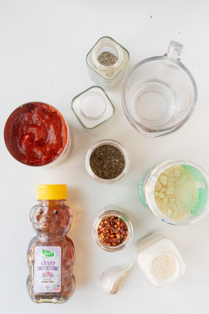 ingredients to make pizza sauce on table.