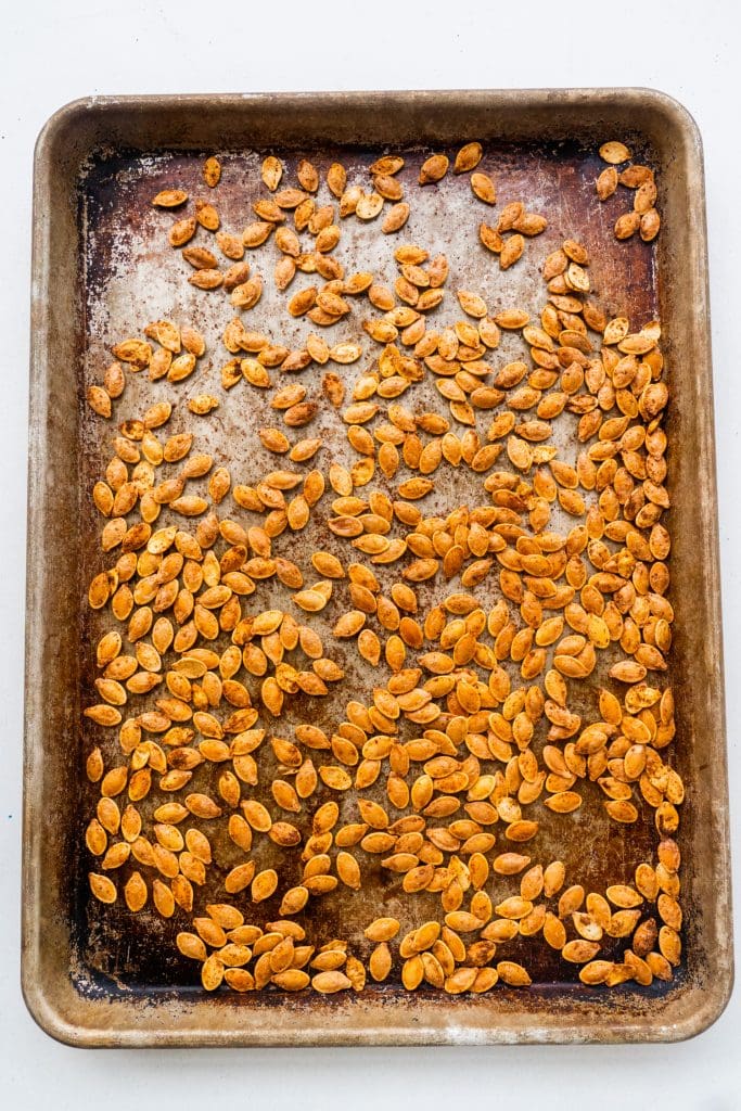 baked pumpkin seeds on baking sheet.