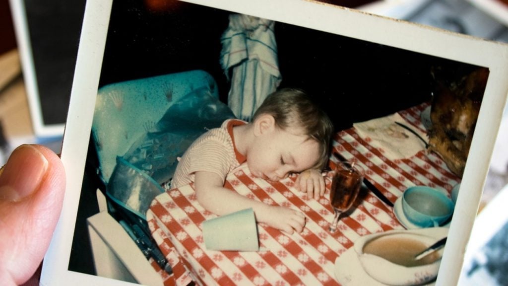vintage polaroid of little boy asleep at dinner table at thanksgiving.