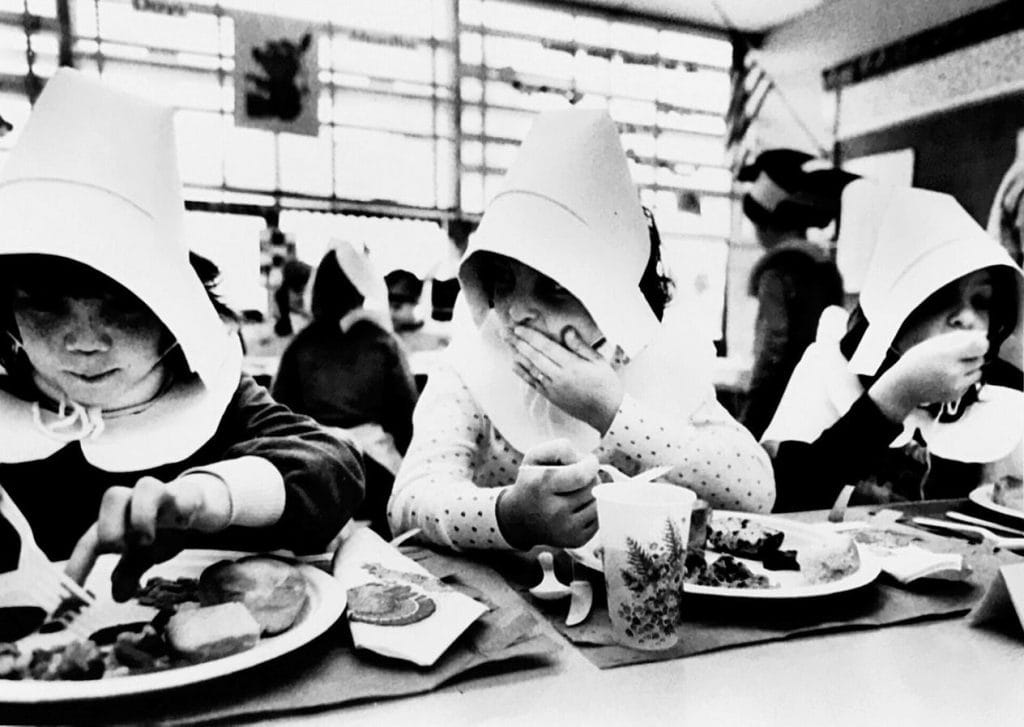 vintage photo of kids at school lunch dressed up as pilgrims.