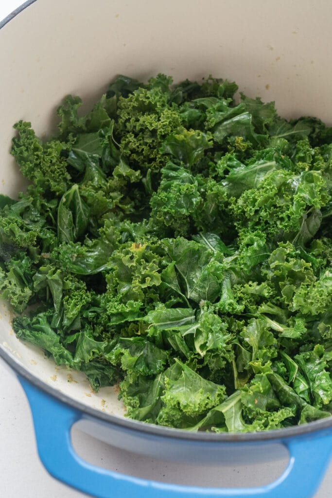 kale wilted in olive oil and garlic in pot.