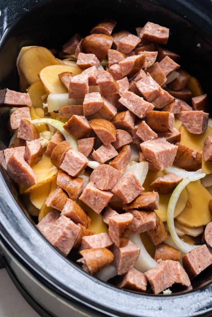 kielbasa added to slow cooker with other ingredients.