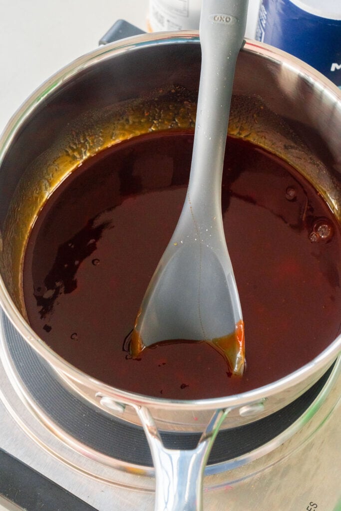 spoon mixing bbq sauce in saucepan.