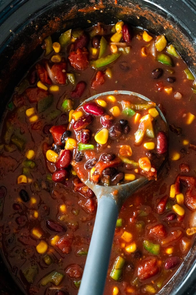 vegetarian chili in the slow cooker with spoon.