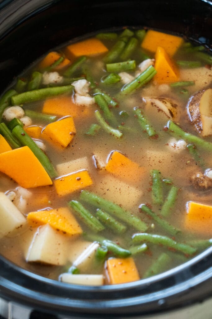 broth and ingredients mixed in slow cooker.