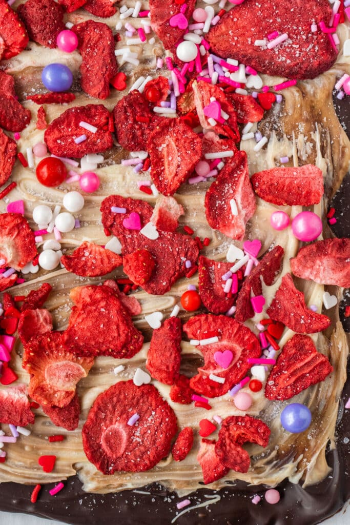 closeup of valentine's chocolate bark with dried strawberries and sprinkles.