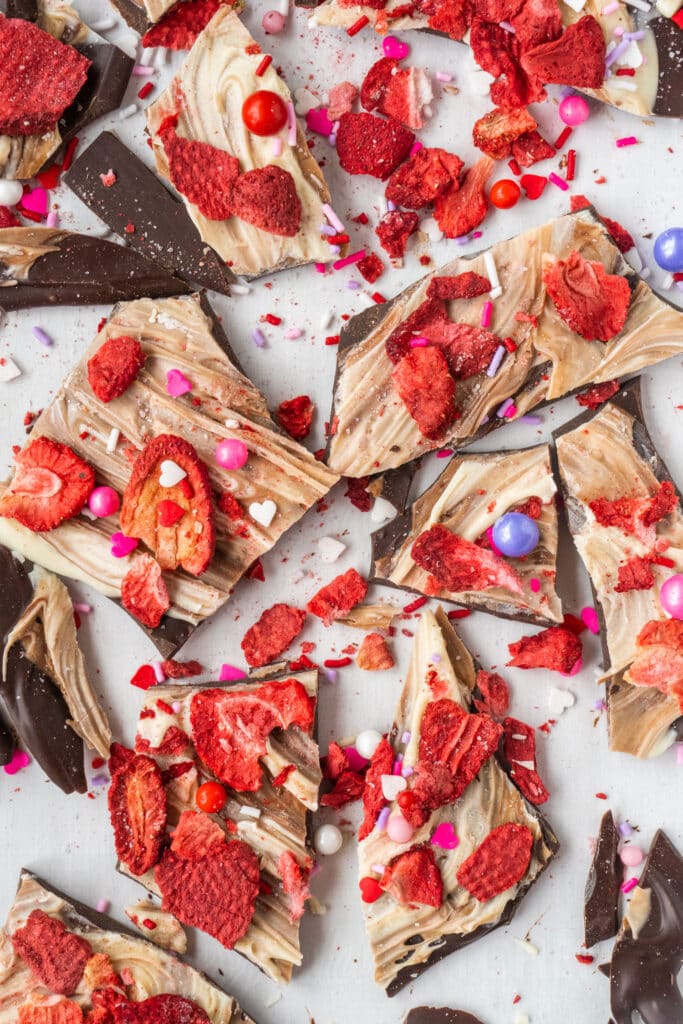 chocolate bark pieces with strawberries and sprinkles on top. 