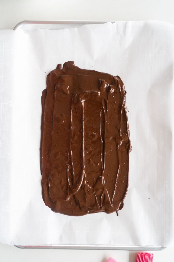 melted chocolate spread out on parchment paper