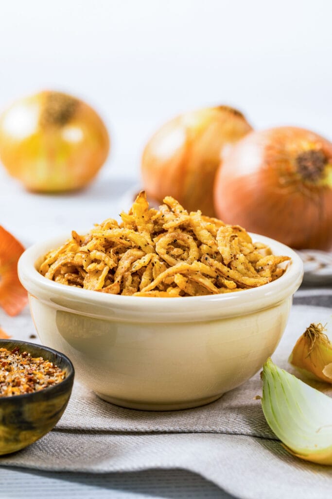 bowl of crispy fried onions on table.