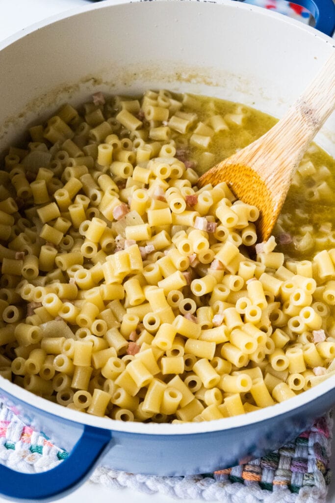 cooked ditalini pasta in pot with pancetta.