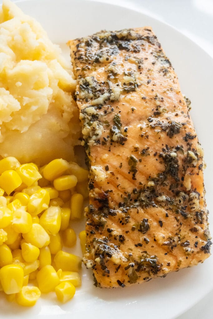 salmon on plate with mashed potatoes and corn.