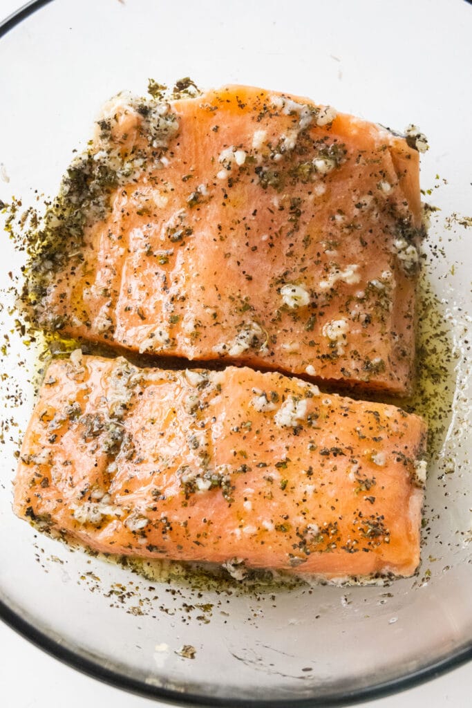salmon covered with marinade in bowl. 
