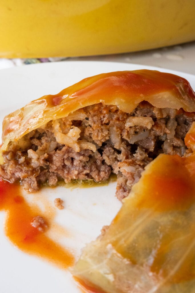 cabbage roll cut open revealing ground beef and rice inside.
