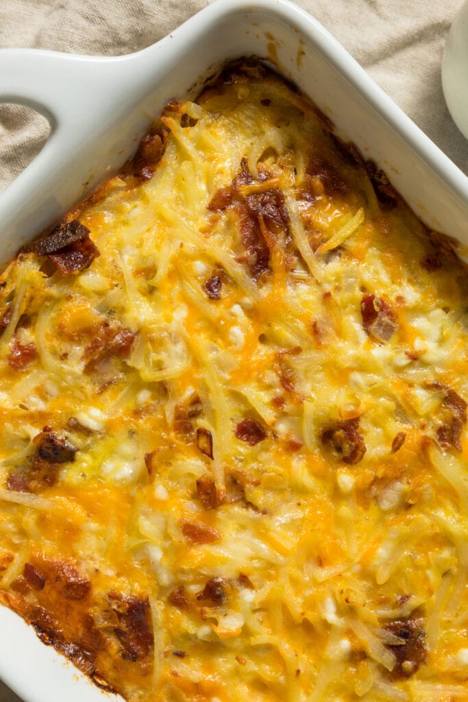 closeup of amish breakfast casserole with sliced bacon and shredded cheese.